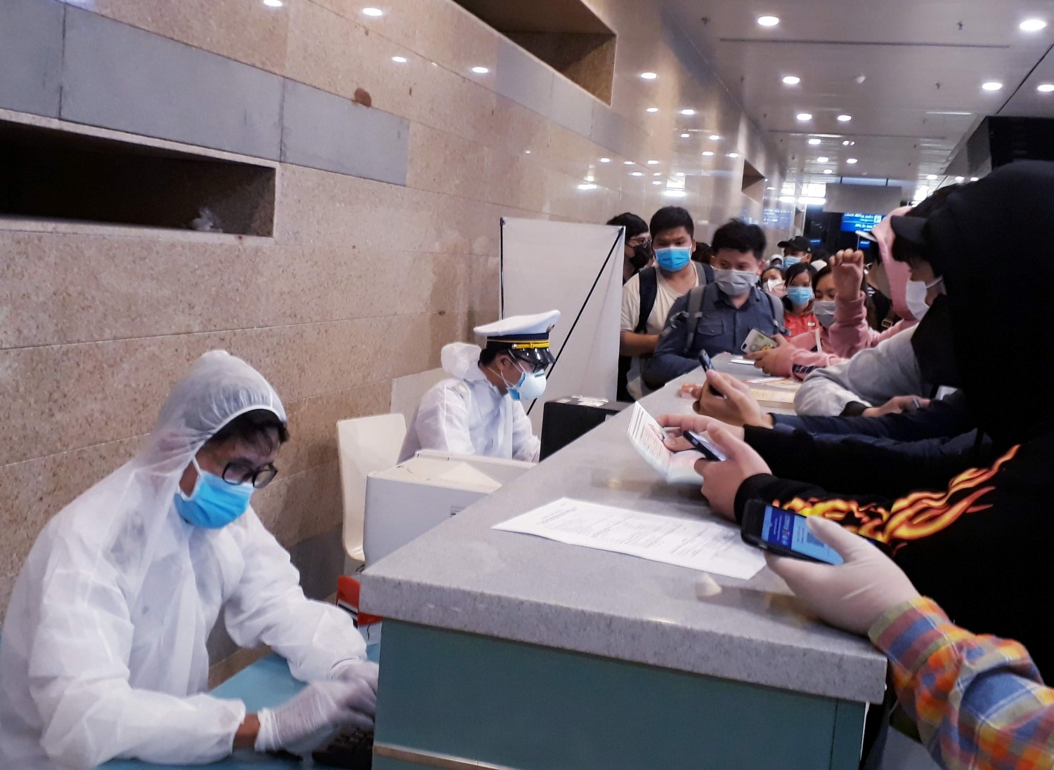 Cán bộ Khoa Phòng chống bệnh truyền nhiễm - kiểm dịch y tế quốc tế hướng dẫn hành khách nhập cảnh khai báo y tế tại Cảng Hàng không quốc tế Cần Thơ