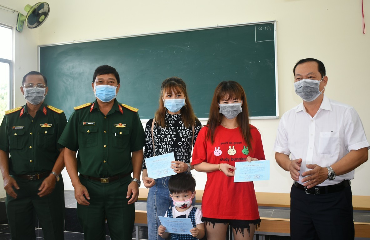 BS.CKII Nguyễn Quang Thông, Giám đốc Trung tâm Kiểm soát bệnh tật thành phố (bìa phải) trao giấy chứng nhận cách ly cho 3 trường hợp hoàn thành thời gian cách ly được trở về địa phương.