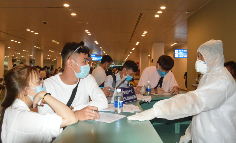 Hành khách trên chuyến bay Đà Nẵng về sân bay Cần Thơ ngày 26/7 được Tổ Kiểm dịch Y tế, Trung tâm Kiểm soát bệnh tật TP Cần Thơ hướng dẫn khai báo y tế và theo dõi sức khỏe. Ảnh: Thái Bình