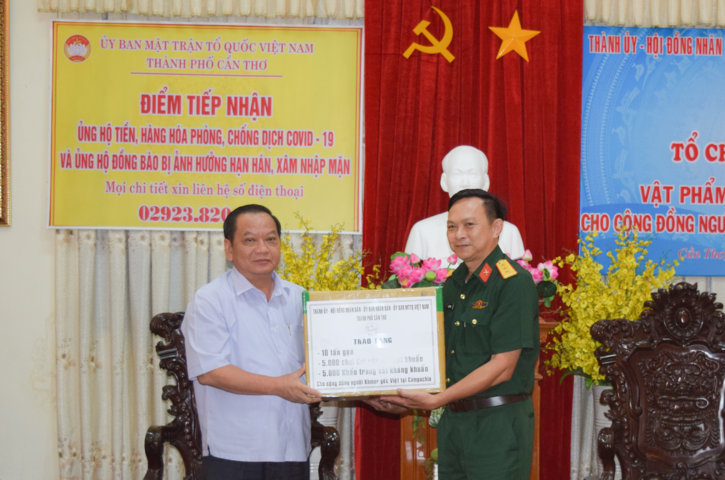Ông Trần Quốc Trung, Bí thư Thành ủy Cần Thơ trao cho Thượng tá Lê Minh Phụng, Phó Chủ nhiệm chính trị, Bộ Chỉ huy Quân sự thành phố phần quà vật phẩm y tế, nhu yếu phẩm cho cộng đồng người Khmer gốc Việt tại Campuchia.