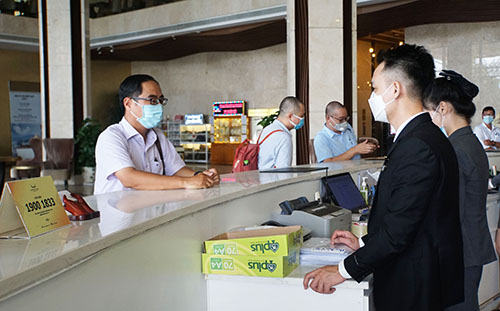 Ông Lâm Hoàng Dũng, Phó Giám đốc Trung tâm Kiểm soát bệnh tật, kiểm tra quy trình đón và phục vụ khách tại quầy tiếp lễ tân Khách sạn Mường Thanh Luxury Cần Thơ.