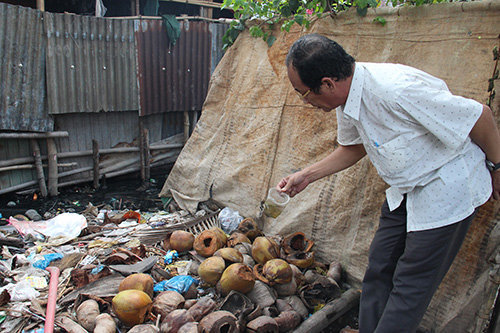 Ông Phạm Phú Trường Giang kiểm tra các vật dụng, rác thải xung quanh nhà dân tại xã Thới Thạnh, huyện Thới Lai.