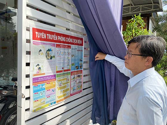 Ông Huỳnh Minh Trúc, Giám đốc CDC Cần Thơ kiểm tra bảng tuyên truyền phòng chống dịch bệnh tại Nhóm trẻ ở phường Thốt Nốt, quận Thốt Nốt.