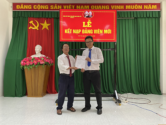 Đồng chí Huỳnh Văn Vũ, Bí thư Chi bộ 3 trao Quyết định của Đảng ủy Khối Cơ quan Dân Chính Đảng về việc kết nạp quần chúng Lê Nguyễn Nhật Minh vào Đảng Cộng sản Việt Nam.