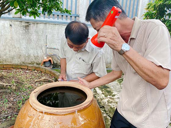 Cán bộ Trạm Y tế phường Long Hoà và cộng tác viên khu vực kiểm tra lăng quăng trong các vật dụng chứa nước.